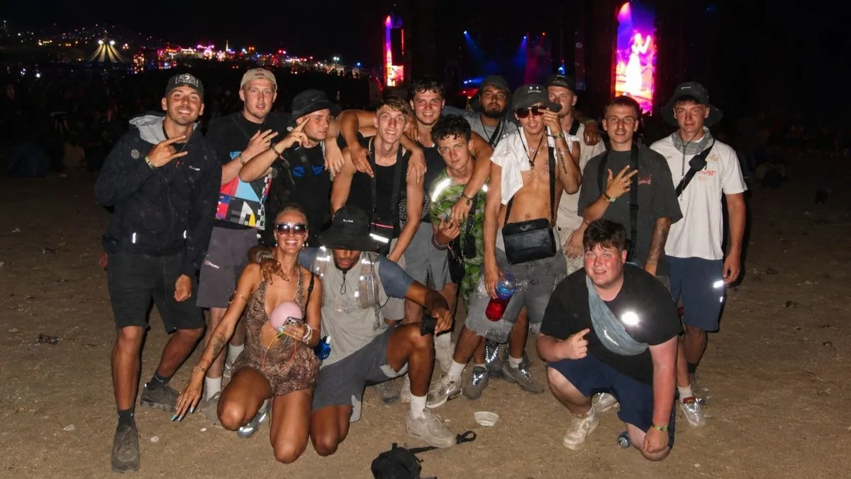 Grupo de jóvenes posa junto durante Boomtown Fair después de compartir varios días en el festival