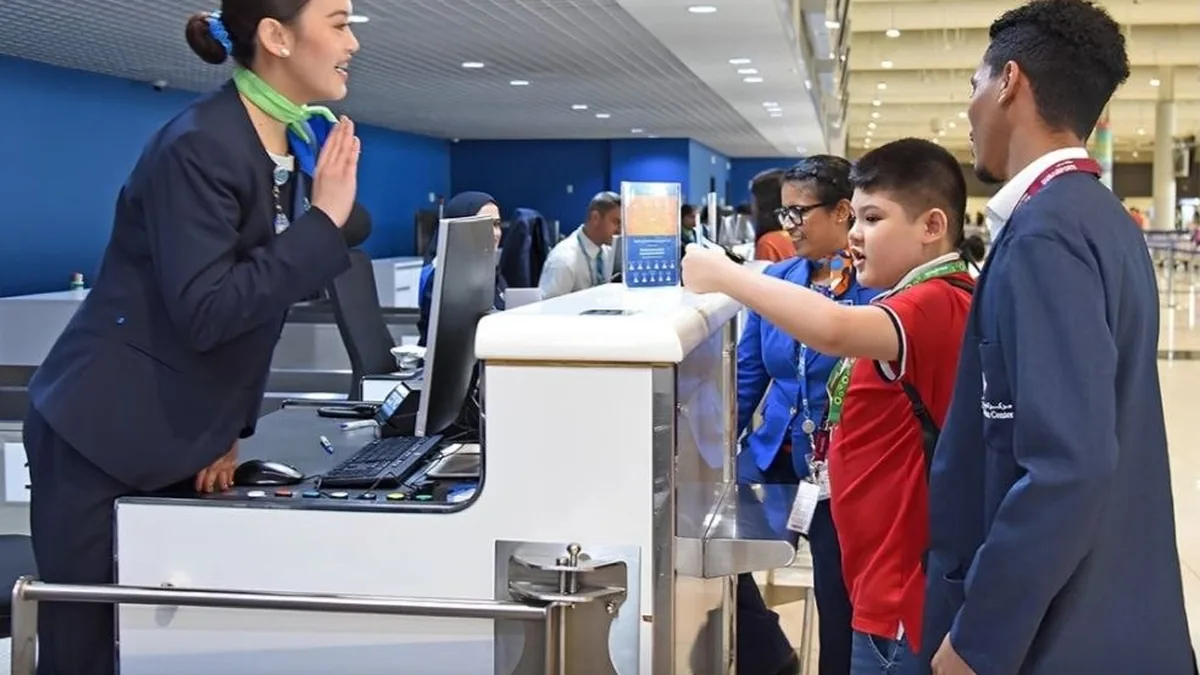 Niño recibe orientación del personal durante el proceso de check-in en el aeropuerto