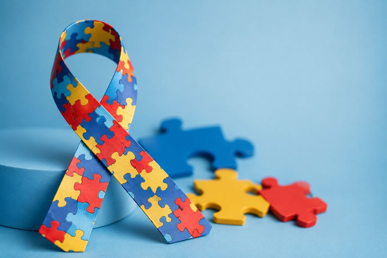 Cinta formada por piezas de colores sobre fondo azul para acompañar un artículo sobre el debate científico del autismo